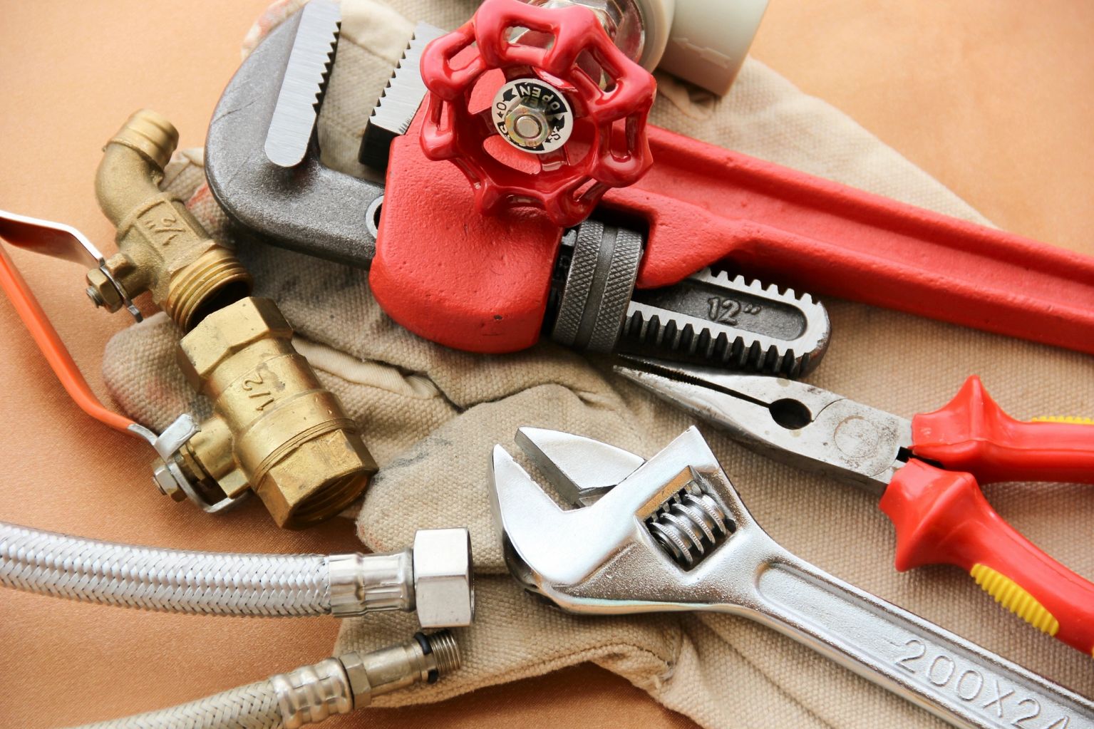 Plumbing tools and a red pipe wrench